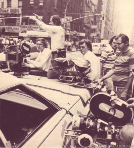 SUPERMAN THE MOVIE- Cameraman Peter McDonald (sitting) and director Richard Donner (with glasses) filming the detectives following Otis. July 8, 1977. New York, U.S. Director- Richard Donner